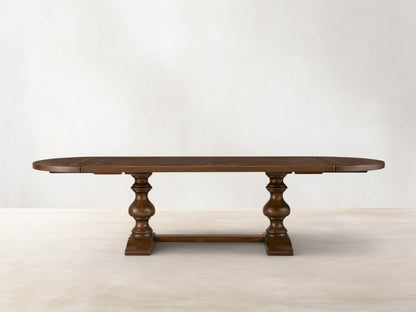 Front view of the brown Stefania Oval Extension Dining Table, with oval top featuring a botanical motif and hand-turned pedestal legs.