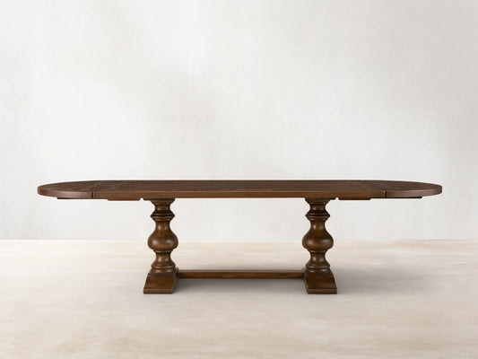 Front view of the brown Stefania Oval Extension Dining Table, with oval top featuring a botanical motif and hand-turned pedestal legs.