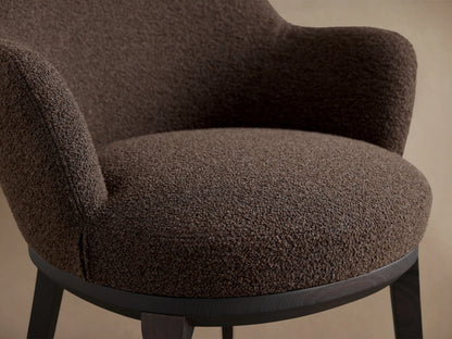 Simone Dining Arm Chair in dark brown fabric, featuring a rounded backrest and armrests, with a solid dark ash wood frame.