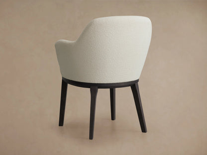 Simone Dining Arm Chair with cream upholstered backrest, dark wooden base, and four tapered legs, viewed from the back.