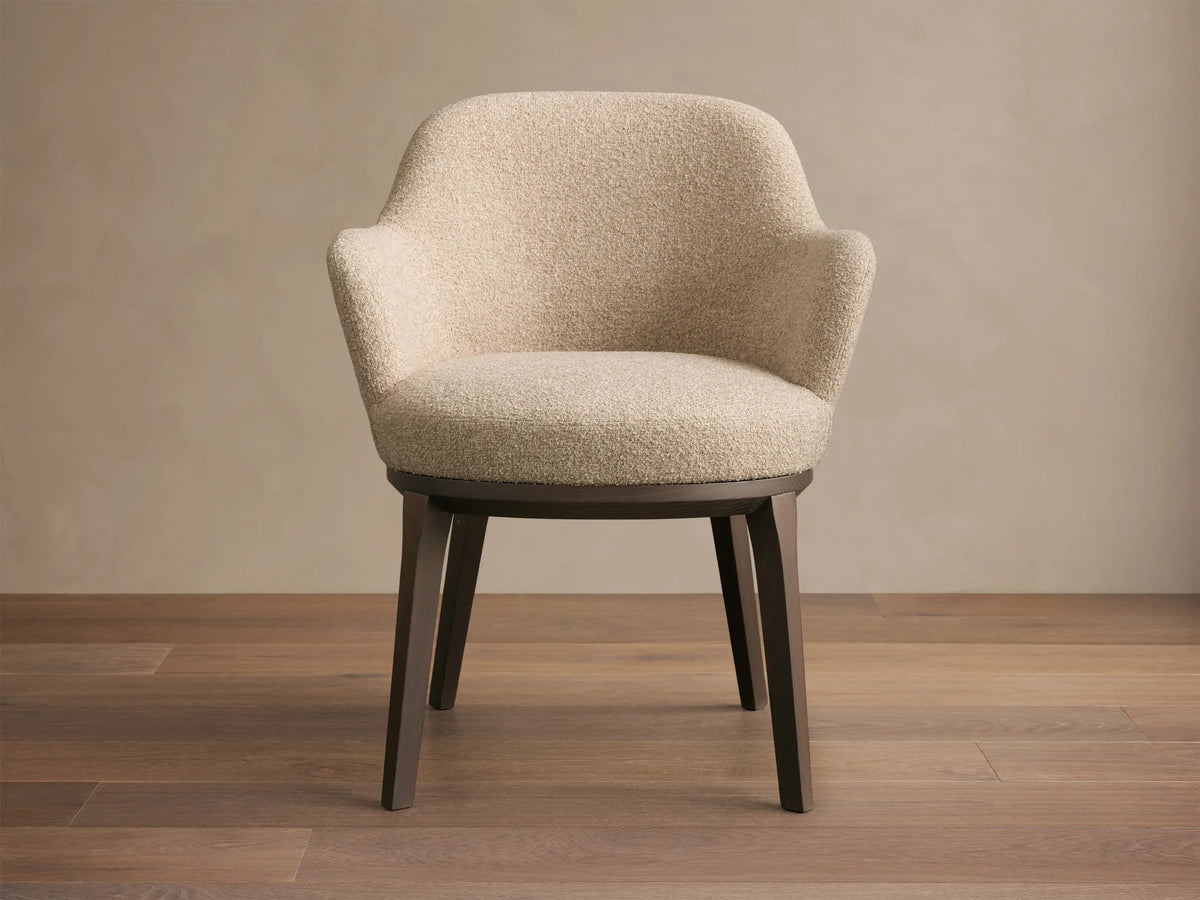 Rear view of the Simone Dining Arm Chair with light beige textured upholstery and dark brown ash wood frame.
