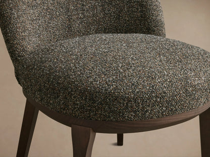 Close-up of the textured brown and grey upholstery on the Simone Dining Side Chair's seat and lower back, with dark wood base.