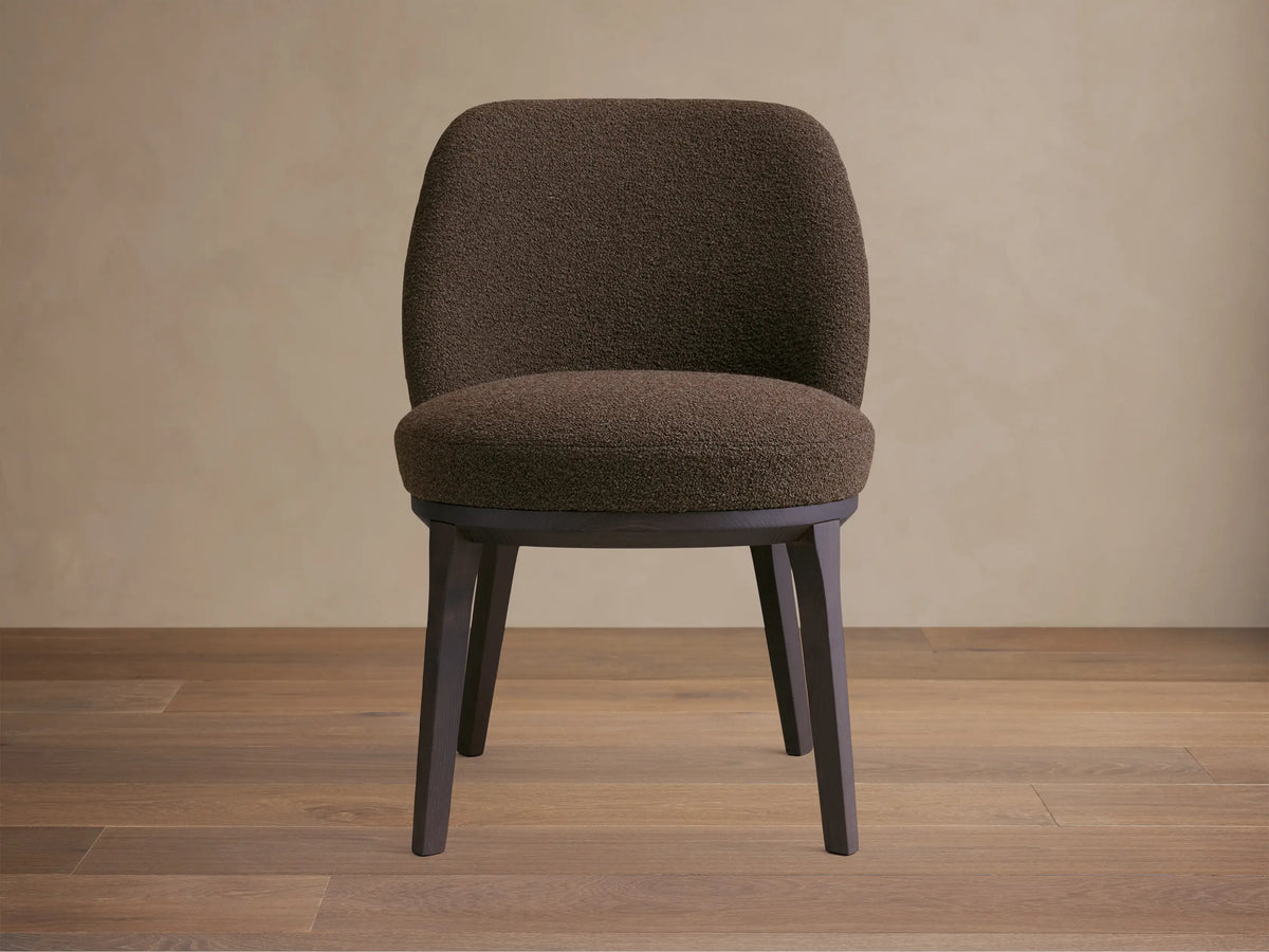 Simone Dining Side Chair in a dark brown textured fabric, featuring a curved backrest and cushioned seat with dark wooden legs.