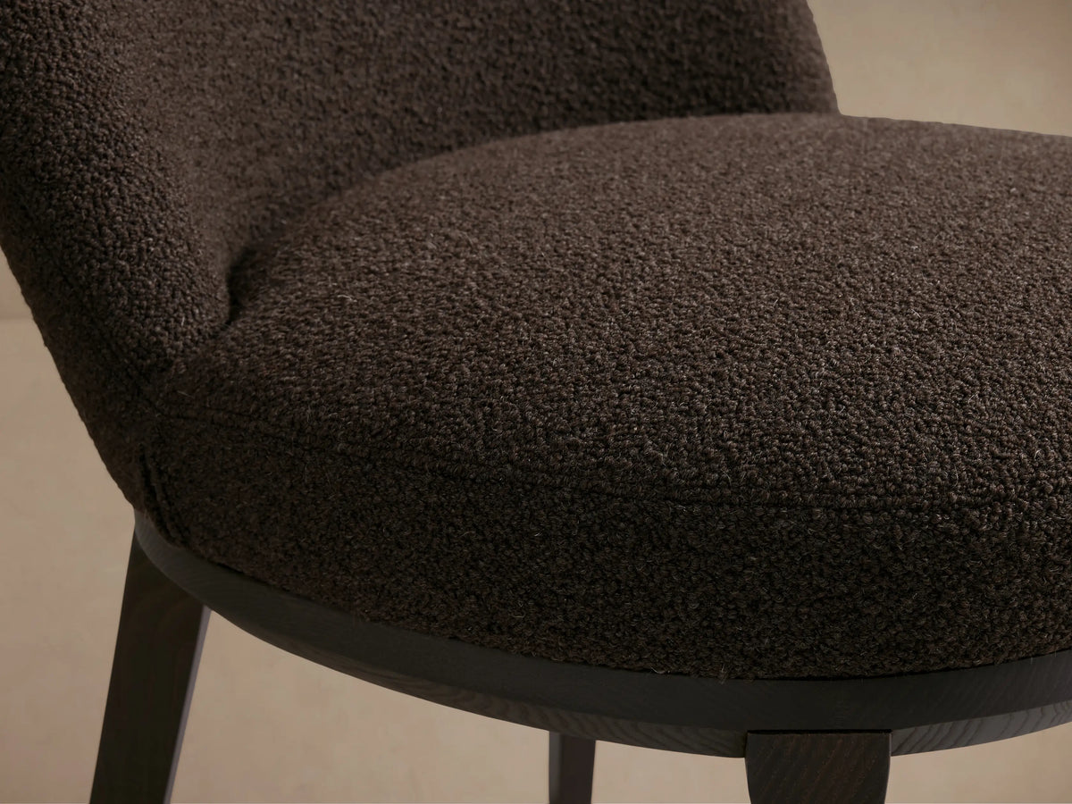 Brown Simone Dining Side Chair with upholstered backrest and seat, solid dark ash wood frame, displayed on wooden floor, beige background.