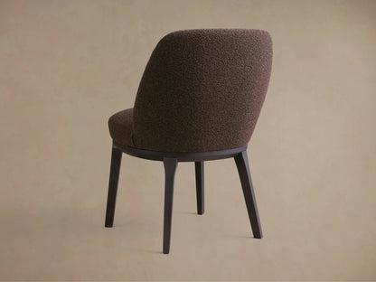 Close-up of the Simone Dining Side Chair featuring a dark brown, textured upholstered seat and backrest, with visible wood frame edges.
