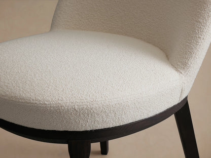 Simone Dining Side Chair with a white upholstered seat and backrest. Features a dark wooden frame on a wooden floor.