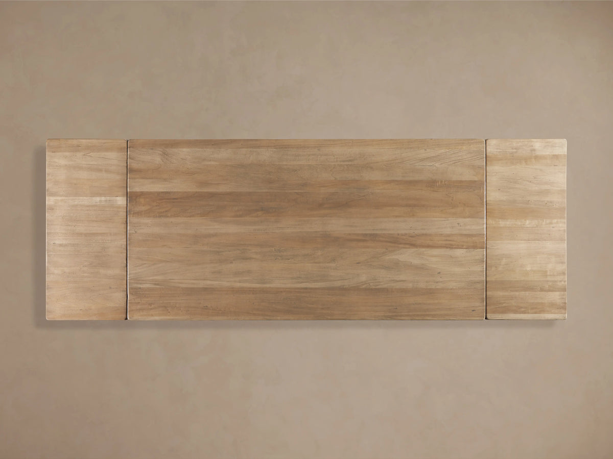 Tuscany Extension Dining Table made of poplar wood, showcasing hand-turned pedestal legs and a horizontal trestle on a wood floor.