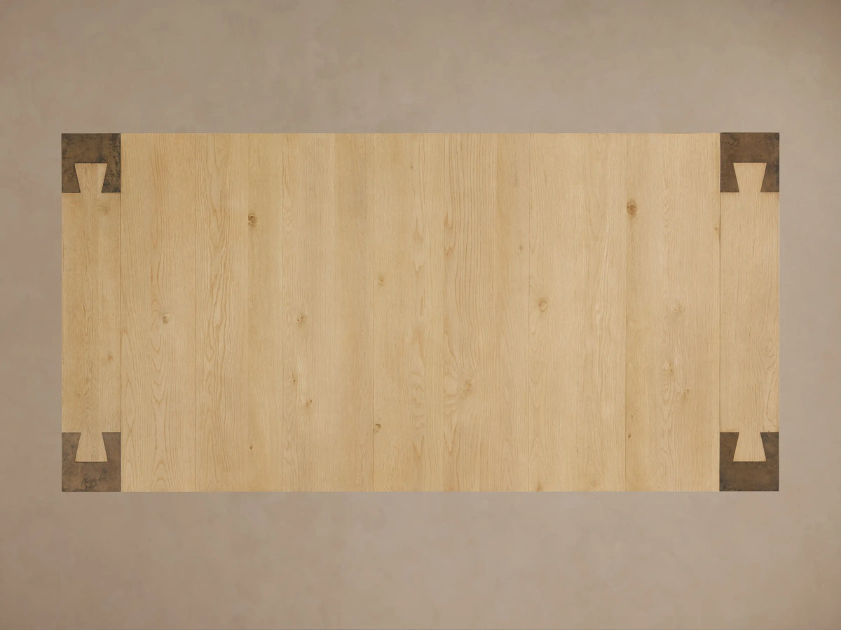 Telluride Dining Table, close-up of light oak wood top with visible grain meeting dark, patinated oxidized steel leg.