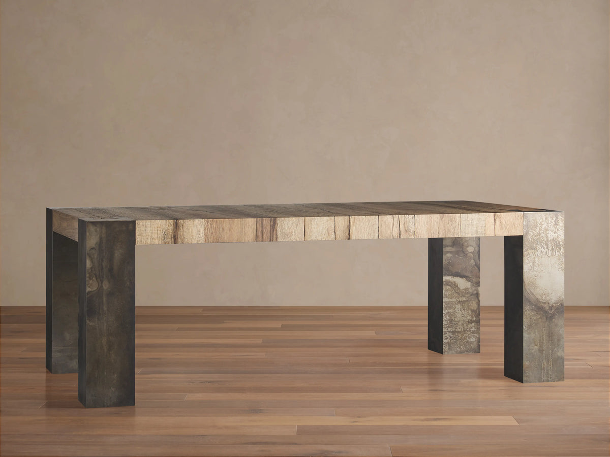 Rectangular Telluride dining table featuring a solid oak wood top with natural variations; oxidized steel legs with distressed patina.