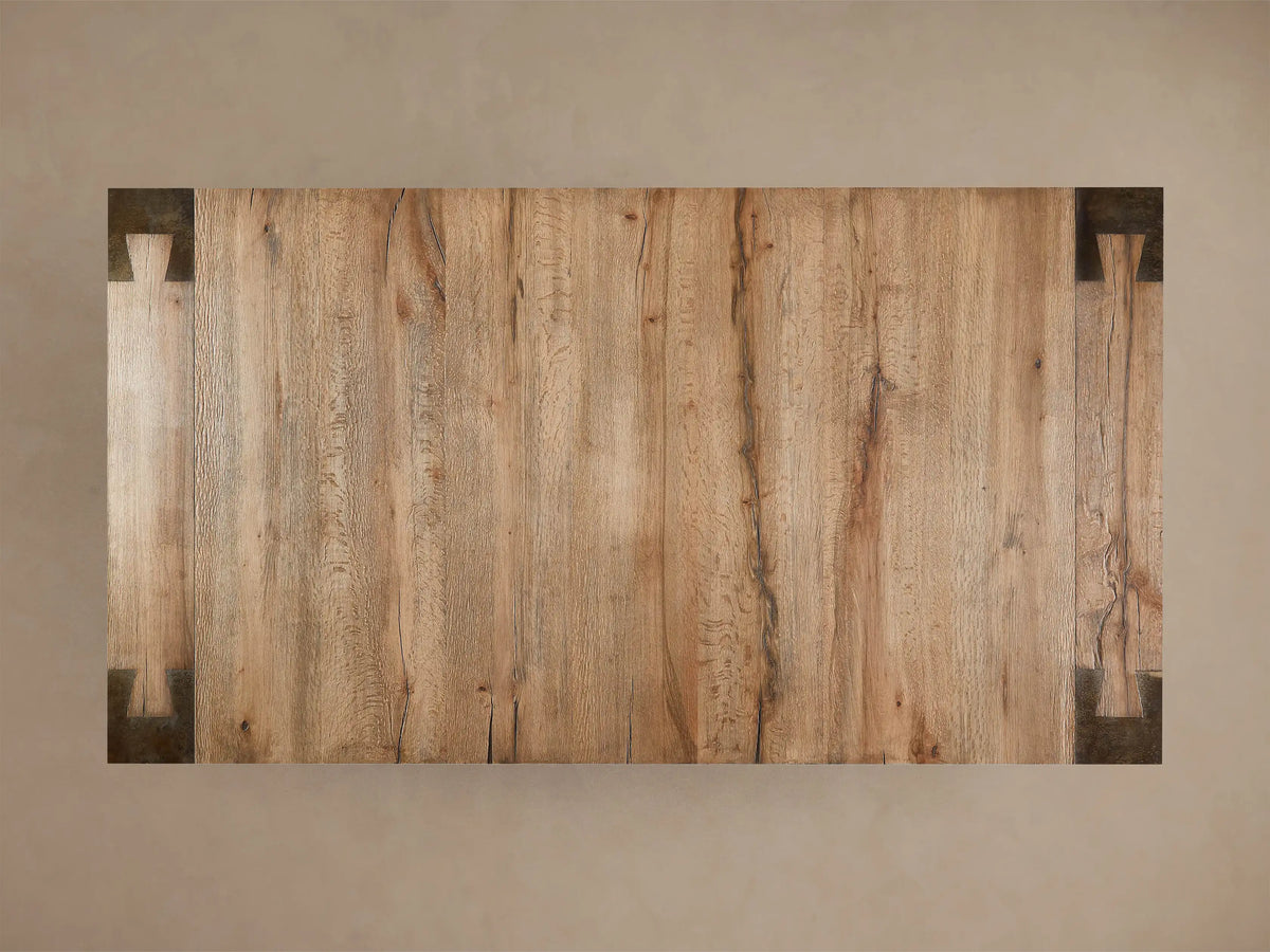 Telluride Dining Table corner showing solid oak top with natural grain and distressed steel leg featuring unique dimpled texture.