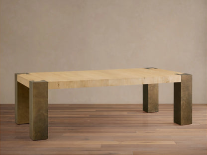 Telluride Dining Table with light wood top, dark oxidized steel legs, and corner accents, angled on a wood floor.
