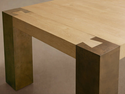 Telluride Dining Table: rectangular light oak top with visible grain, square weathered dark bronze steel legs, wood floor.