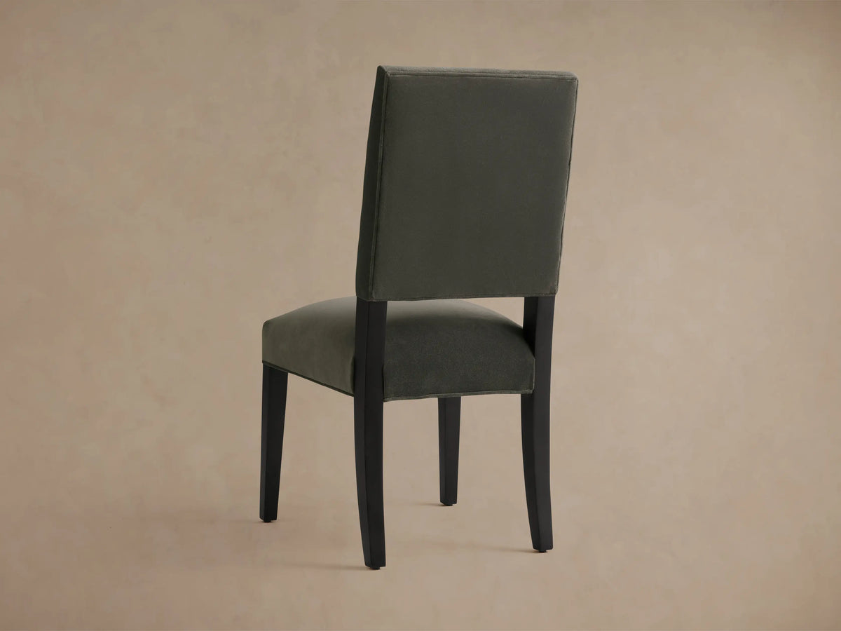 Torino Dining Chair with a plush grey upholstered seat and back, featuring sleek black solid maple tapered legs, angled for stability.