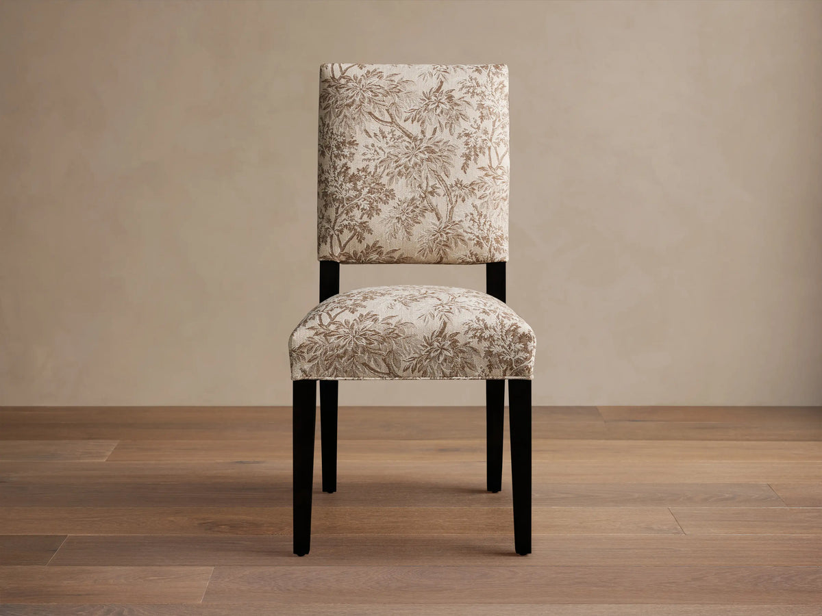 Torino Dining Chair with floral-patterned beige upholstery, dark tapered maple legs, on a wooden floor in a neutral setting.