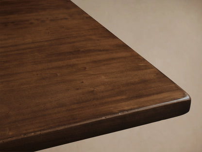Tuscany Extension Dining Table made from solid poplar wood with a rich finish, features pedestal legs and a horizontal trestle on a wooden floor.