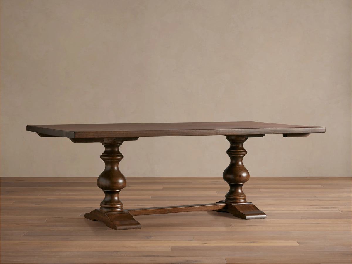 Tuscany Extension Dining Table with a dark brown poplar wood finish, featuring two hand-turned pedestal legs and horizontal trestle.