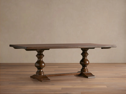 Tuscany Extension Dining Table with a dark brown poplar wood finish, featuring two hand-turned pedestal legs and horizontal trestle.