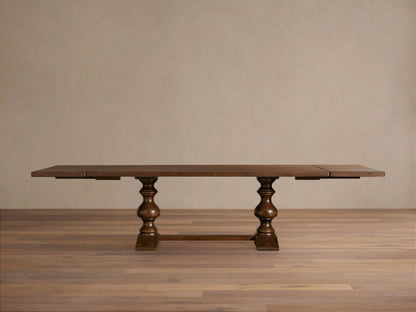 Tuscany Extension Dining Table in warm brown poplar wood, features hand-turned pedestal legs, horizontal trestle, and antiqued finish.