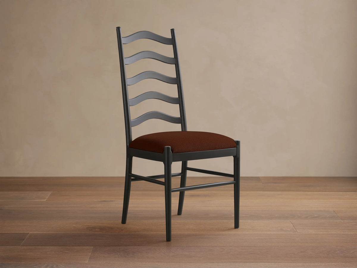 Front view of the black Vivianna Dining Side Chair with a wavy ladder-back and a brown padded seat.