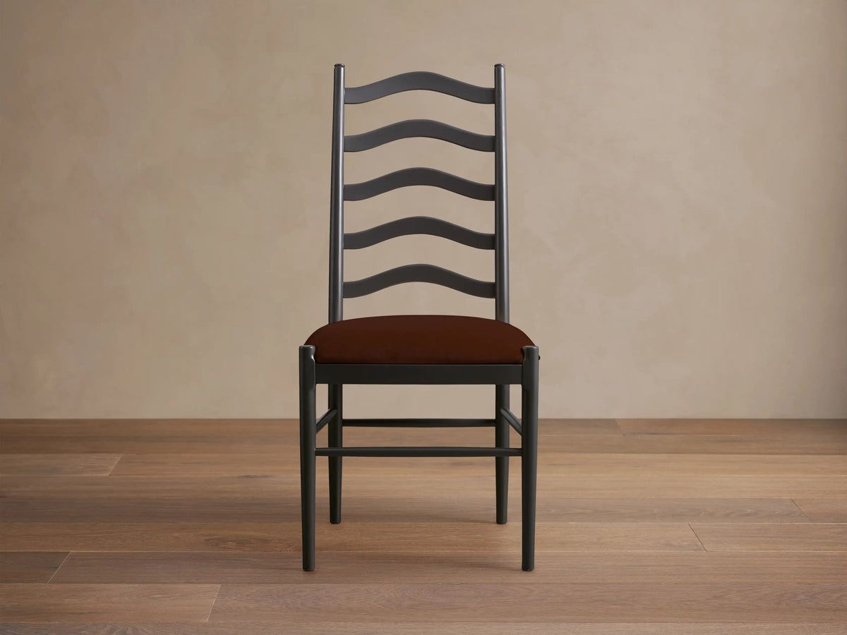 Front view of the black Vivianna Dining Side Chair with a wavy ladder-back and a brown padded seat.