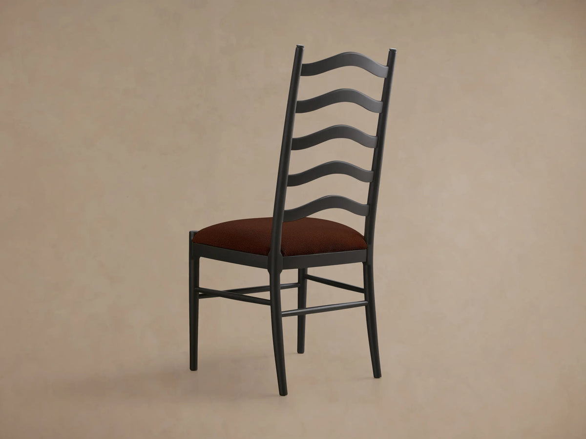 Front view of a dark gray Vivianna Dining Side Chair with a ladder-back design featuring wavy slats and a rust upholstered seat.
