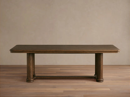 Warby Extension Dining Table in dark wood finish, featuring a rectangular top and two cylindrical pedestal legs on a wooden floor.