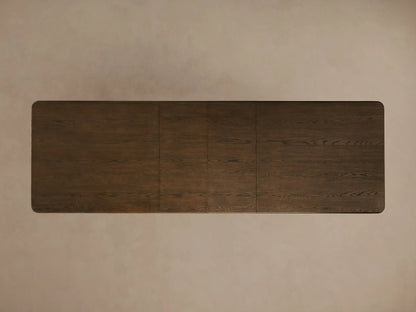Dark wood Warby Extension Dining Table with large round legs and a smooth, textured finish on a neutral surface.