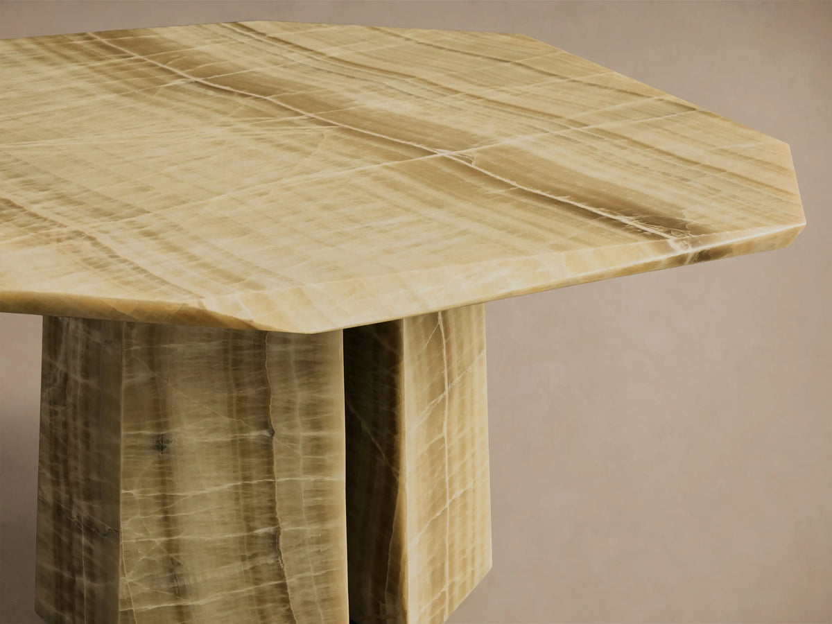 Close-up of the green onyx Zyra Round Dining Table, featuring its asymmetrical tabletop and split pedestal base with natural veining.