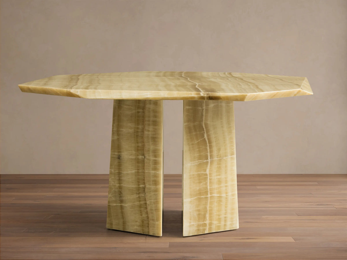 Front view of the green onyx Zyra Round Dining Table, showing its asymmetrical tabletop and split pedestal base with natural veining.