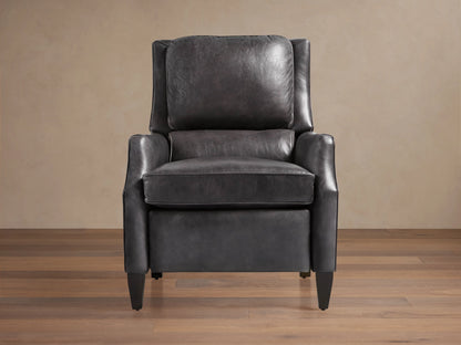 Alex Leather Recliner, dark gray, angled front-right. Features wingback design, contrast piping, tapered dark wood legs, on wood floor.
