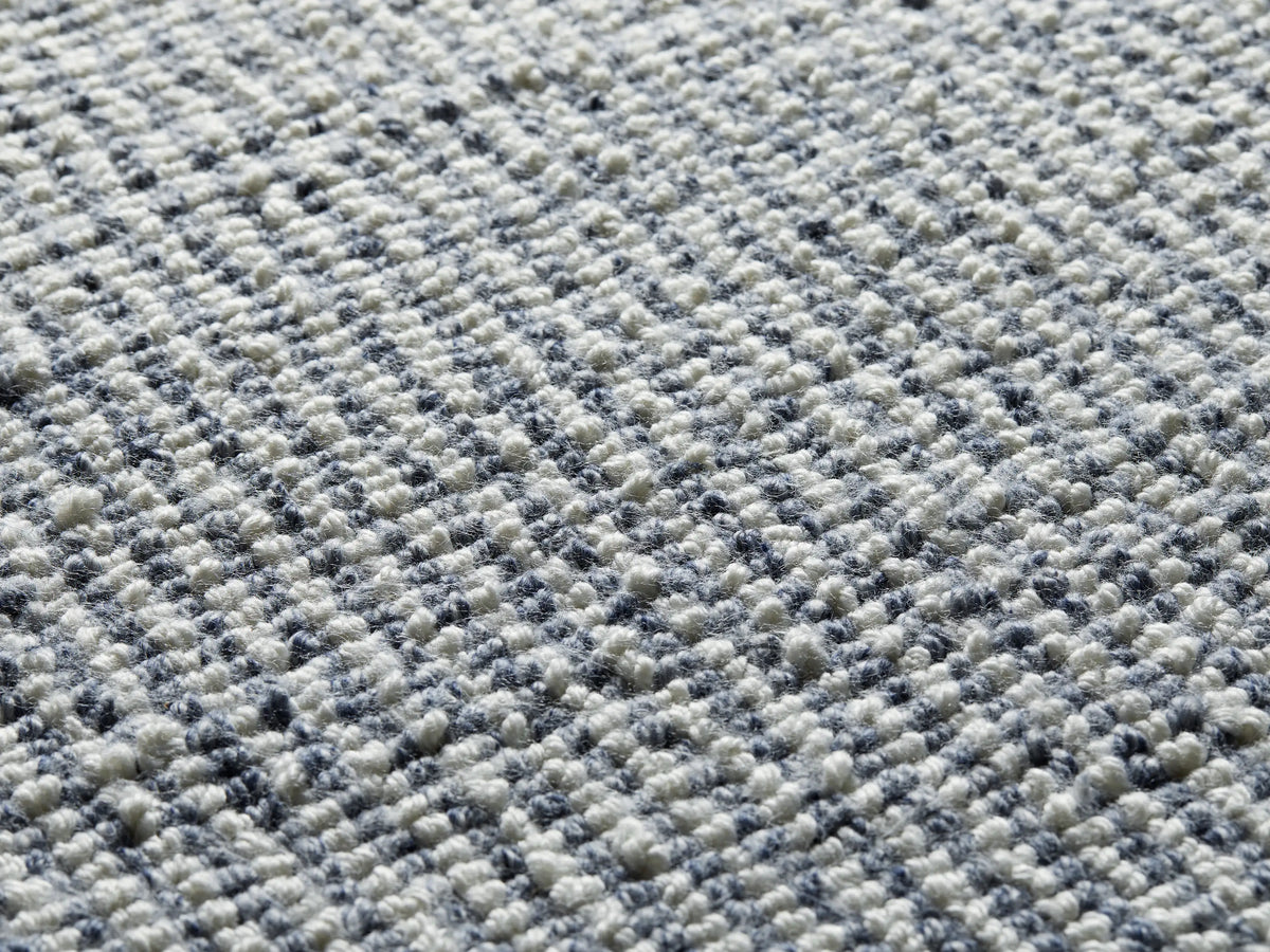 Maddux Performance Rug close-up, showing a textured, speckled weave of white and dark blue/grey fibers.