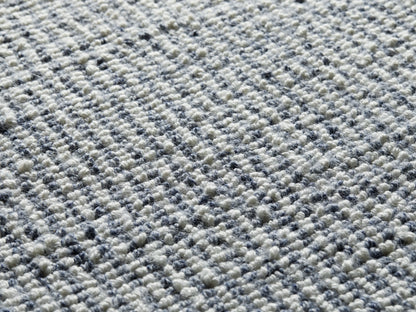 Maddux Performance Rug close-up, showing a textured, speckled weave of white and dark blue/grey fibers.