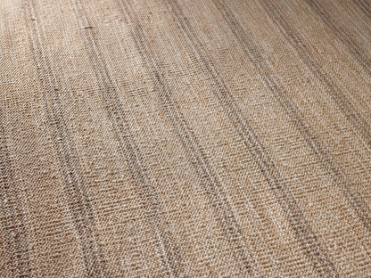 Rectangular Grover Performance Rug, beige with vertical dark stripes, dark grey left and right borders, flat on tan floor.