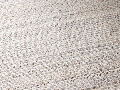 Sansa Performance Runner Rug, light rectangular braided rug with subtle inner rectangular border, on a gray floor.