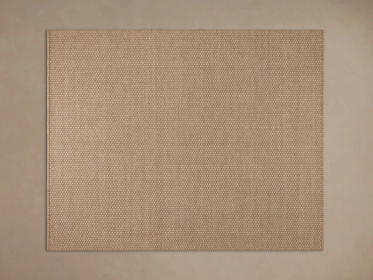 Hatcher Performance Rug with dense beige & brown weave, on a dark wood floor, partially under a light wood coffee table.