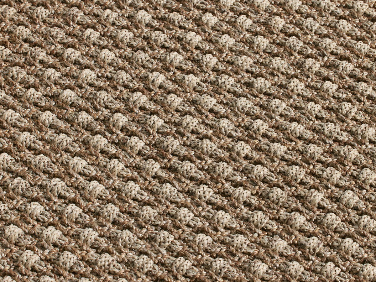 Hatcher Performance Rug. Rectangular, light brown, tightly woven rug with a textured basketweave pattern, viewed from above.