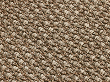Hatcher Performance Rug. Rectangular, light brown, tightly woven rug with a textured basketweave pattern, viewed from above.