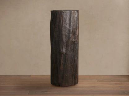 Closed Log Bar, upright, dark brown reclaimed wood, textured like a natural log, on a brown wooden floor against a beige wall.