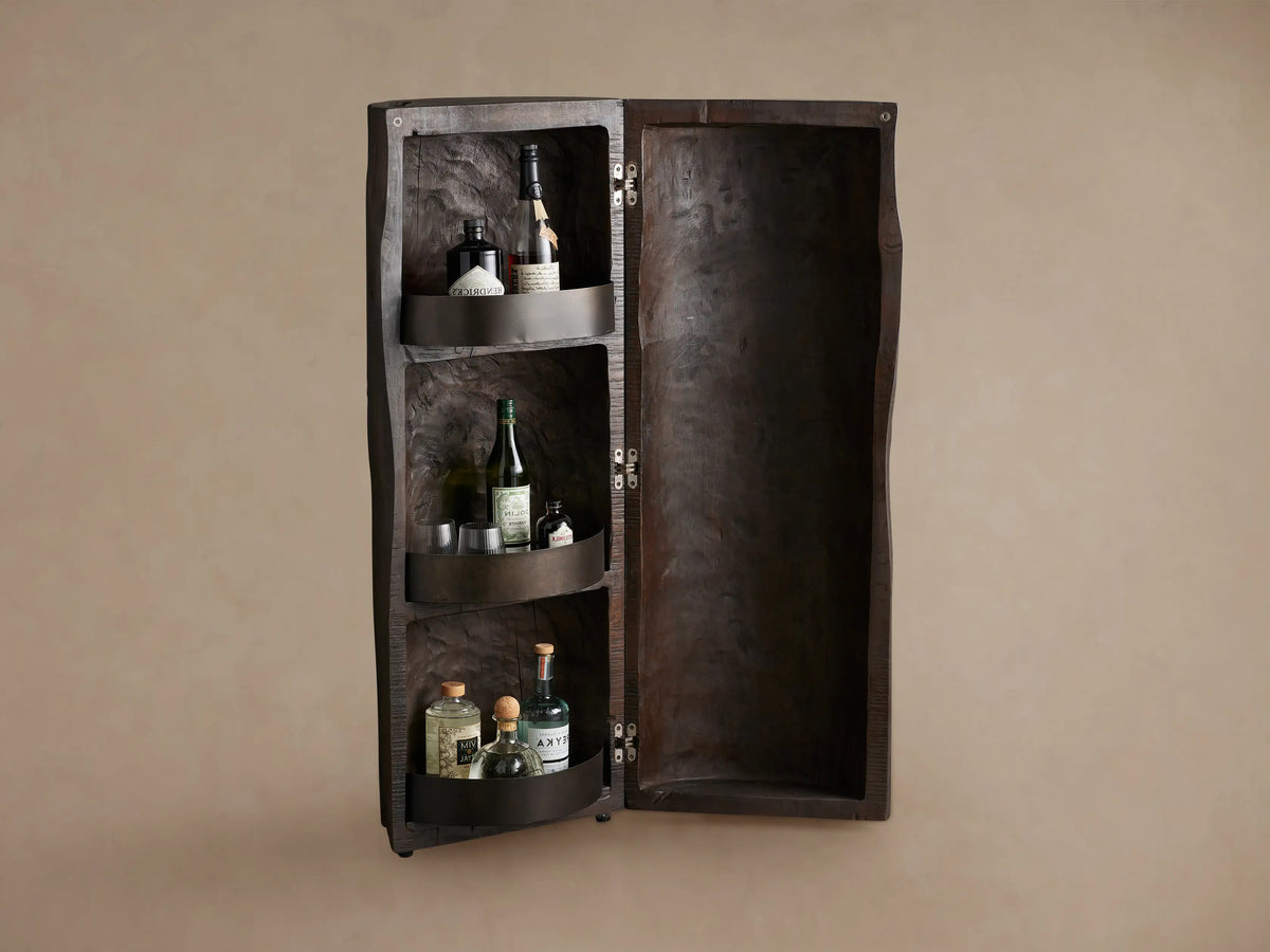 Closed Log Bar, upright, dark brown reclaimed wood, textured like a natural log, on a brown wooden floor against a beige wall.