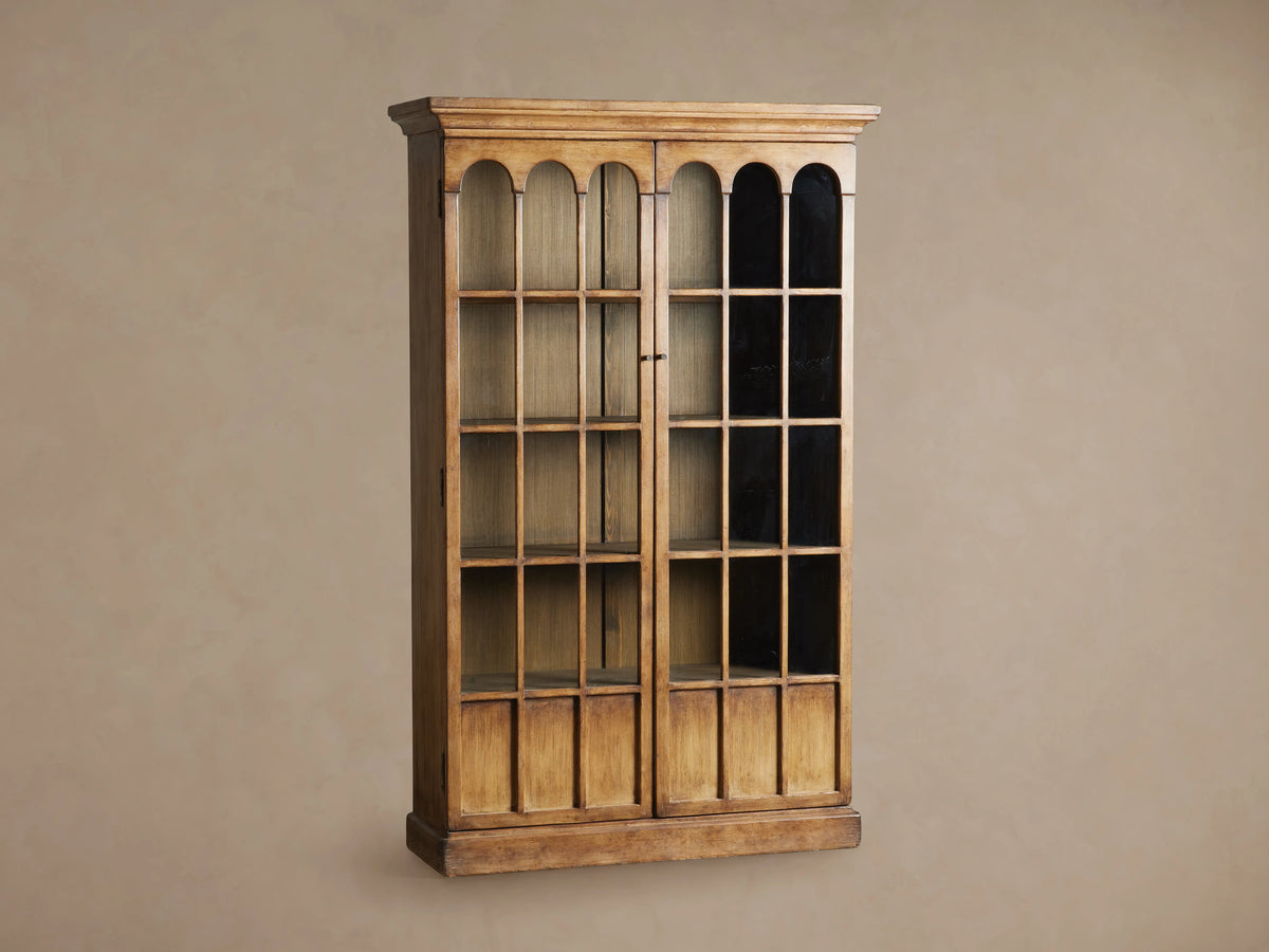Handcrafted Merritt Cabinet made of solid pine wood with a honey-brown finish. Features glass-paneled doors with antiqued brass hardware.