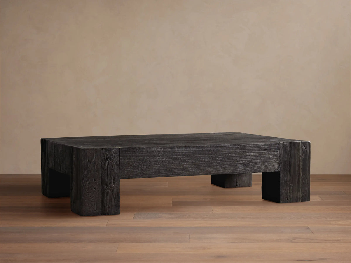 Ubud Coffee Table, square and low, made of dark reclaimed teak wood with prominent grain texture, on a wood floor.