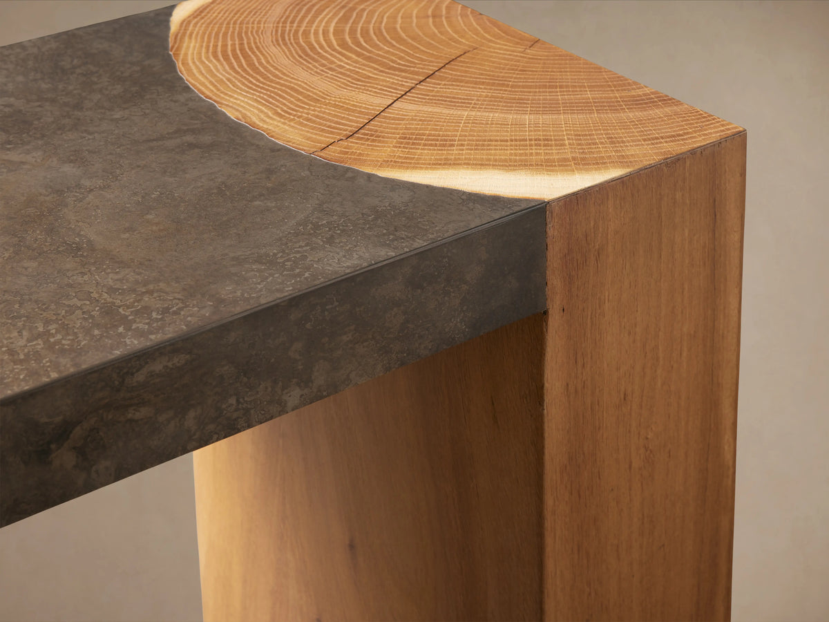 Acacius Console Table corner showing a dark oxidized steel top with a light wood edge, smooth texture, and natural wood grain.