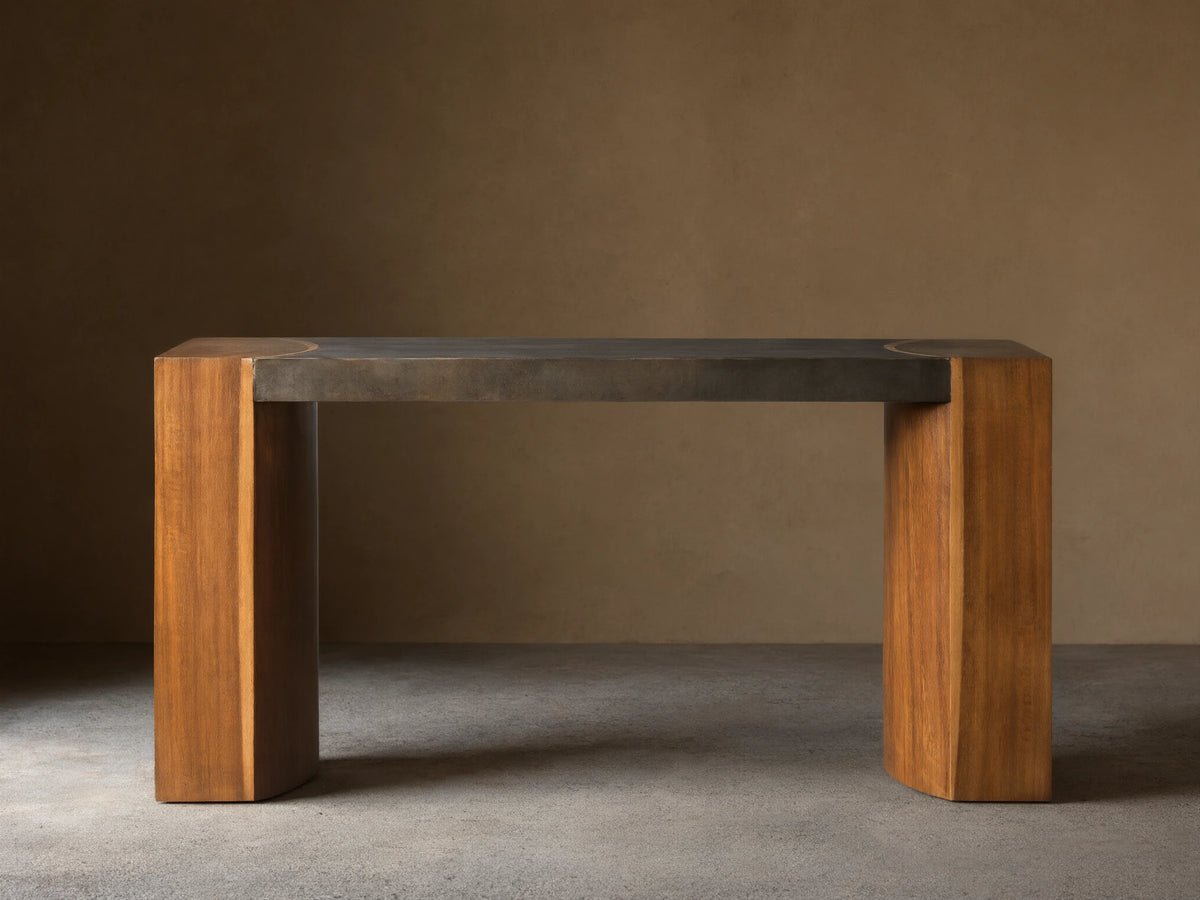 Acacius Console Table with oxidized steel top and thick legs made from reclaimed yukas wood, against a beige wall.