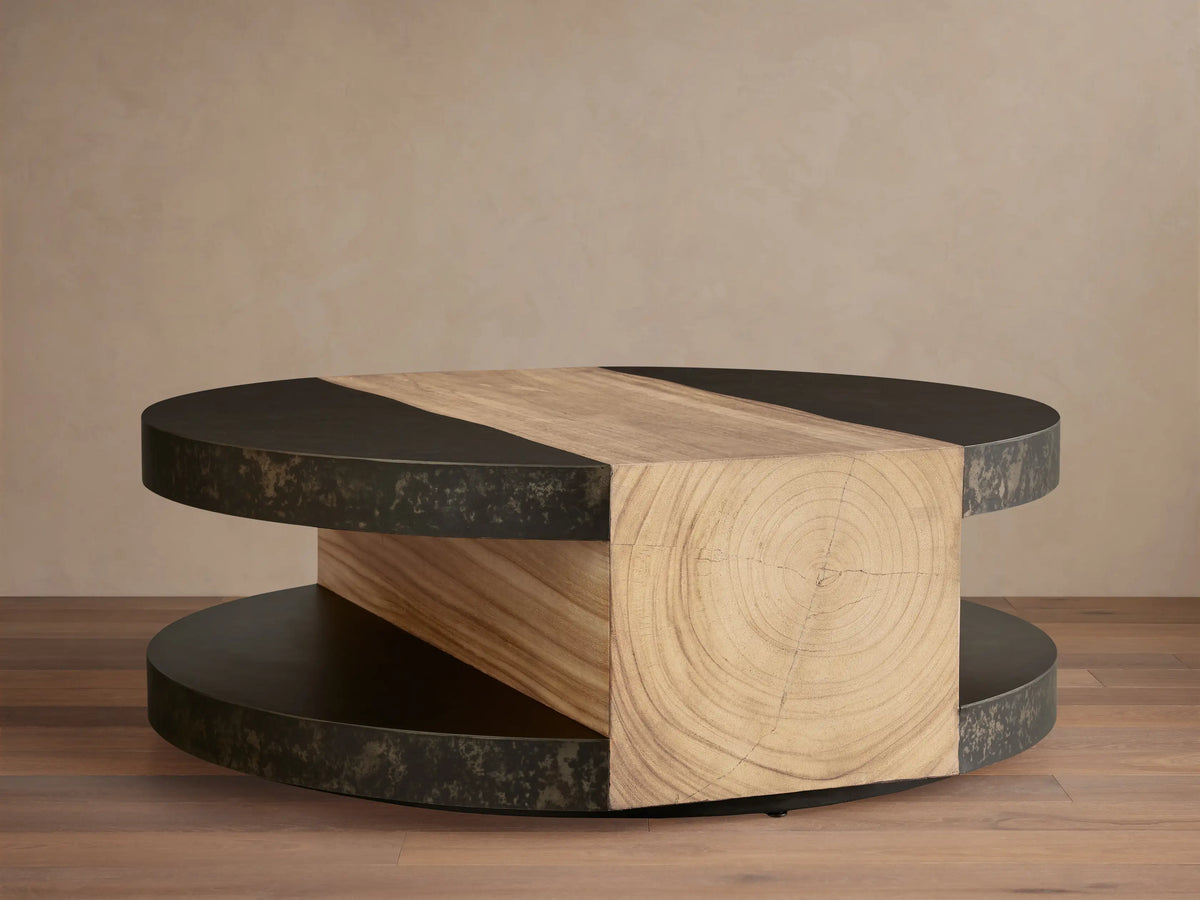 Front view of Almeria Round Coffee Table. Dark oxidized steel discs and angled guanacaste wood block with end grain.