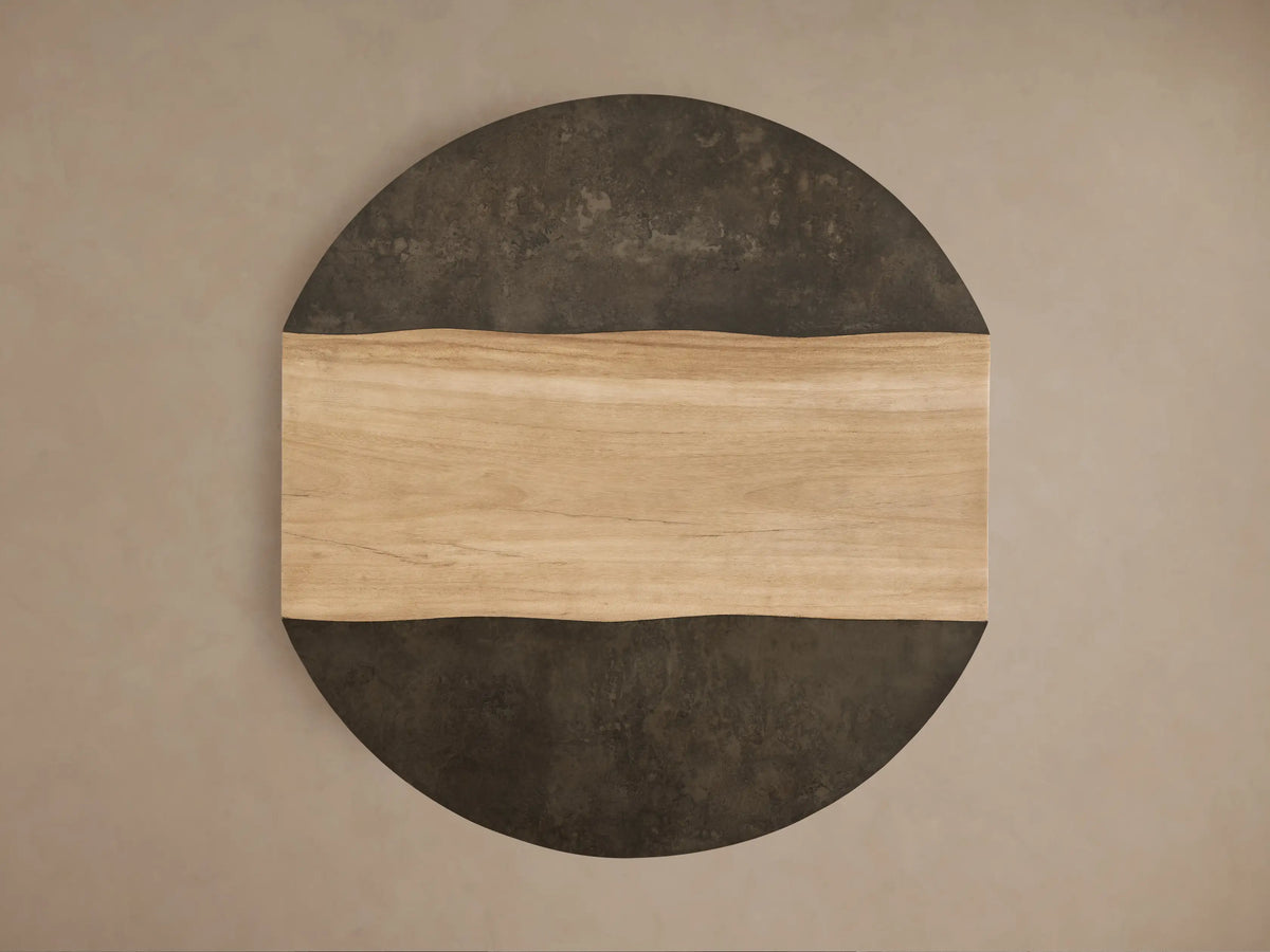 Front view of the Almeria Round Coffee Table, with a light brown guanacaste wood center and wavy dark gray oxidized steel edges.