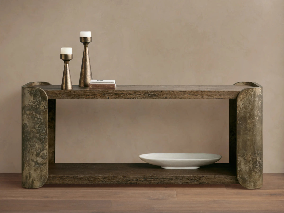 Alvaro Console Table: two dark spalted primavera wood shelves, curved weathered aluminum sides with patina. Candlesticks, white bowl.