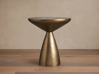 Amina End Table in polished bronze finish, featuring an inverted cone top and tapered base, placed on wood floor.