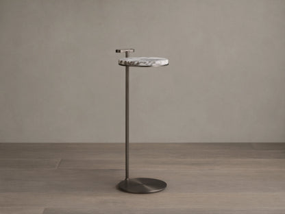 Front view of Anorah Martini Table with a round white marble top featuring gray veining, a dark metallic stand, and integrated handle.