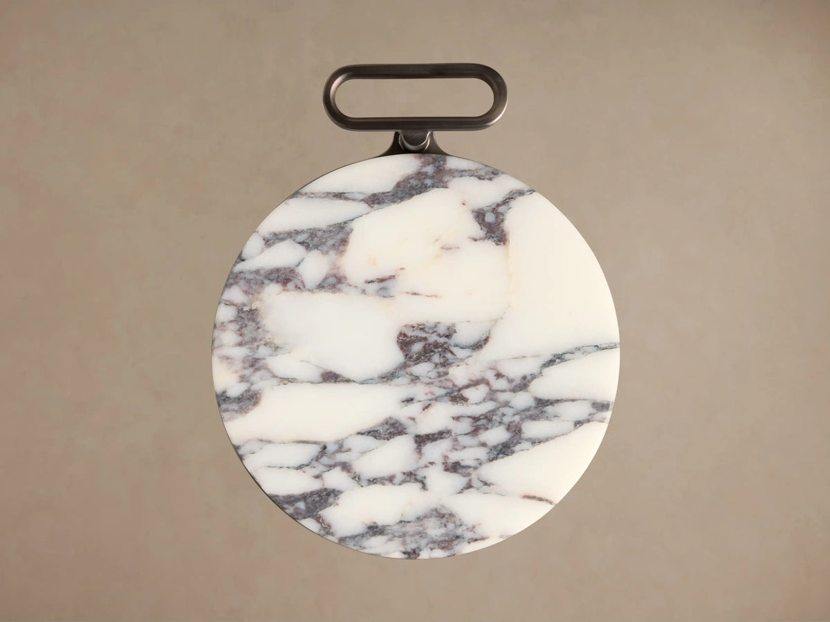 Close-up of the Anorah Martini Table's round white marble top with burgundy veining and dark gray integrated handle.