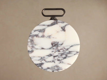 Close-up of the Anorah Martini Table's round white marble top with burgundy veining and dark gray integrated handle.